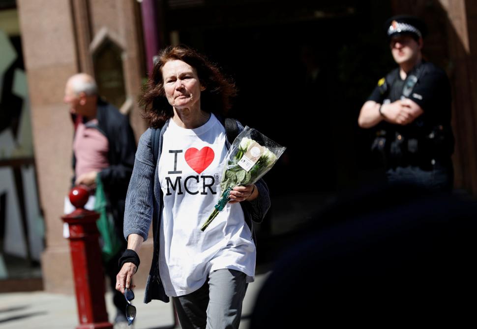 Una mujer pone flores para las víctimas del ataque Manchester Arena, en el centro de Manchester. REUTERS