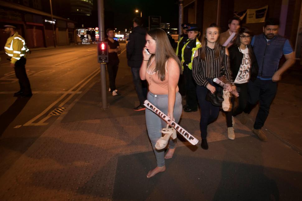 Los espectadores del concierto realizan llamadas a sus seres queridos luego de huir del Manchester Arena. REUTERS