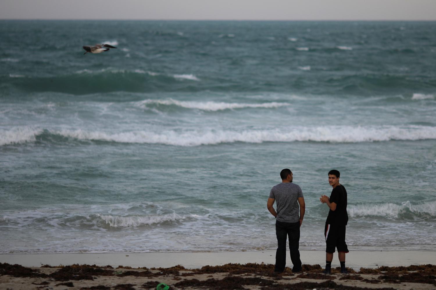 MAR MOVIDO. Dos personas observan el mar, que ya tiene el oleaje agitado a causa de la cercanía del huracán. REUTERS