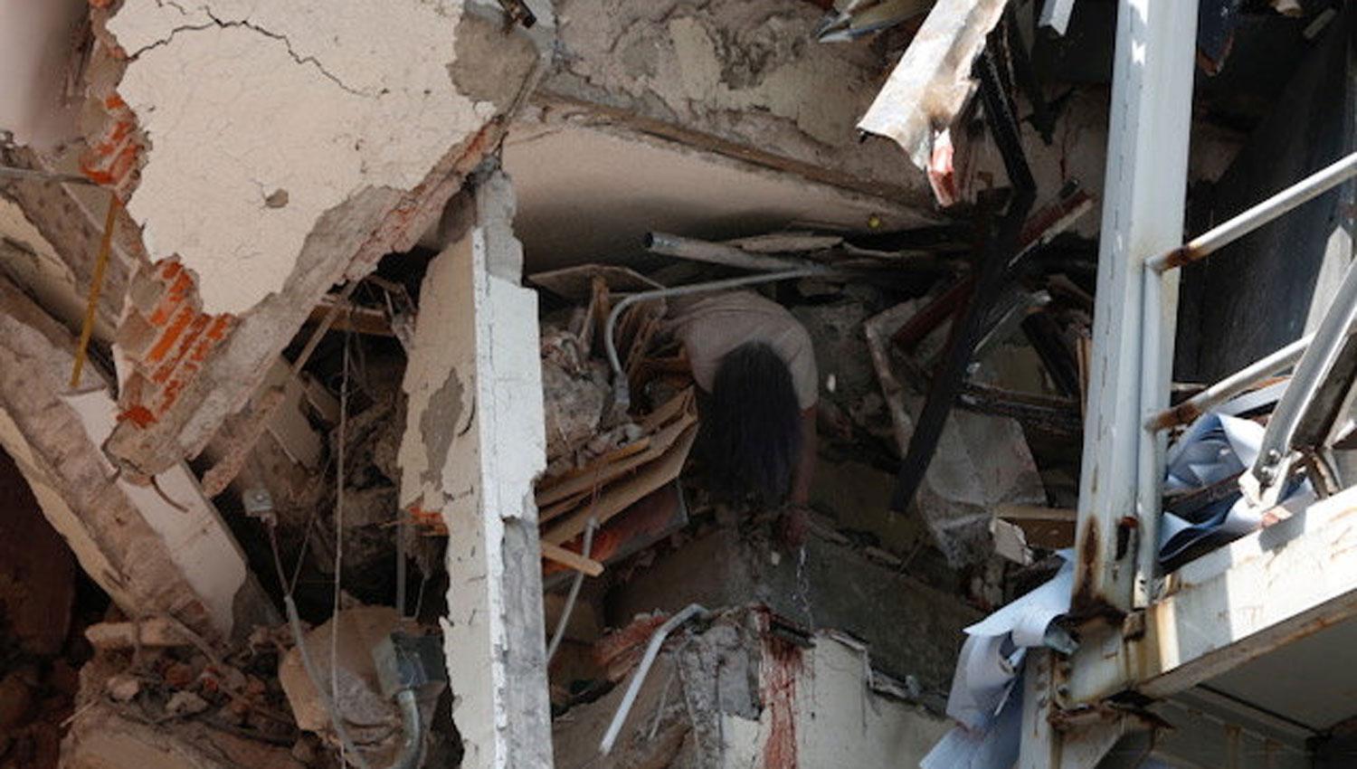 El cadáver de una mujer aparece entre los escombros de un edificio. REUTERS