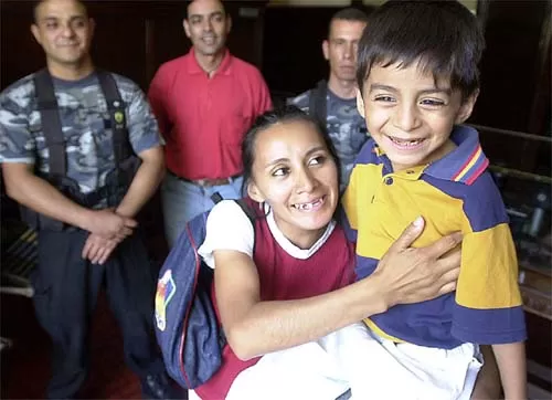 Y VIO LA LUZ. En brazos de su mamá, Braian sonríe, rodeado por la gente que lo ayuda día a día. 