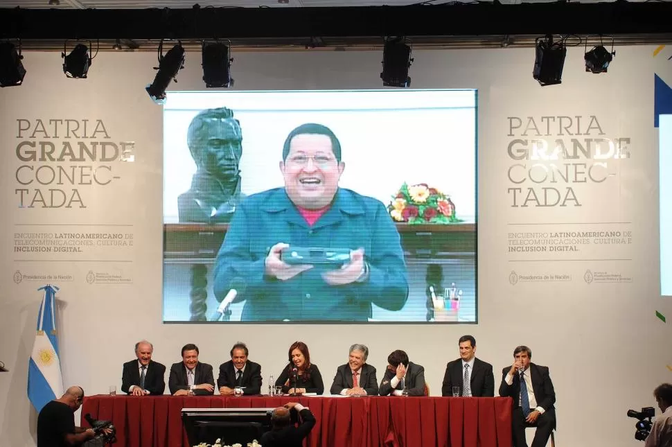 EN TECNOPOLIS. La Presidenta bromeó con Chávez durante la videoconferencia. El resto de los participantes festejan la ocurrencia de Cristina. TELAM