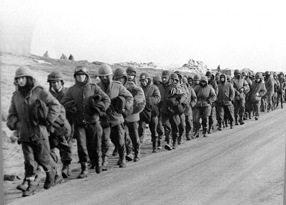 EL ÚLTIMO DÍA. Desconsolados y presionados por el frío, las tropas argentinas marchan desarmadas luego de rendirse ante la supremacía británica. DYN