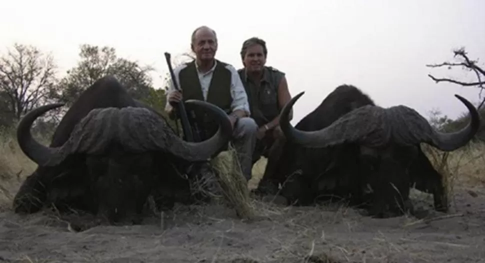 MATADOR. El rey, junto a dos búfalos recién cazados, en una foto de Rann Safaris. FOTO TOMADA DE ELMUNDO.ES