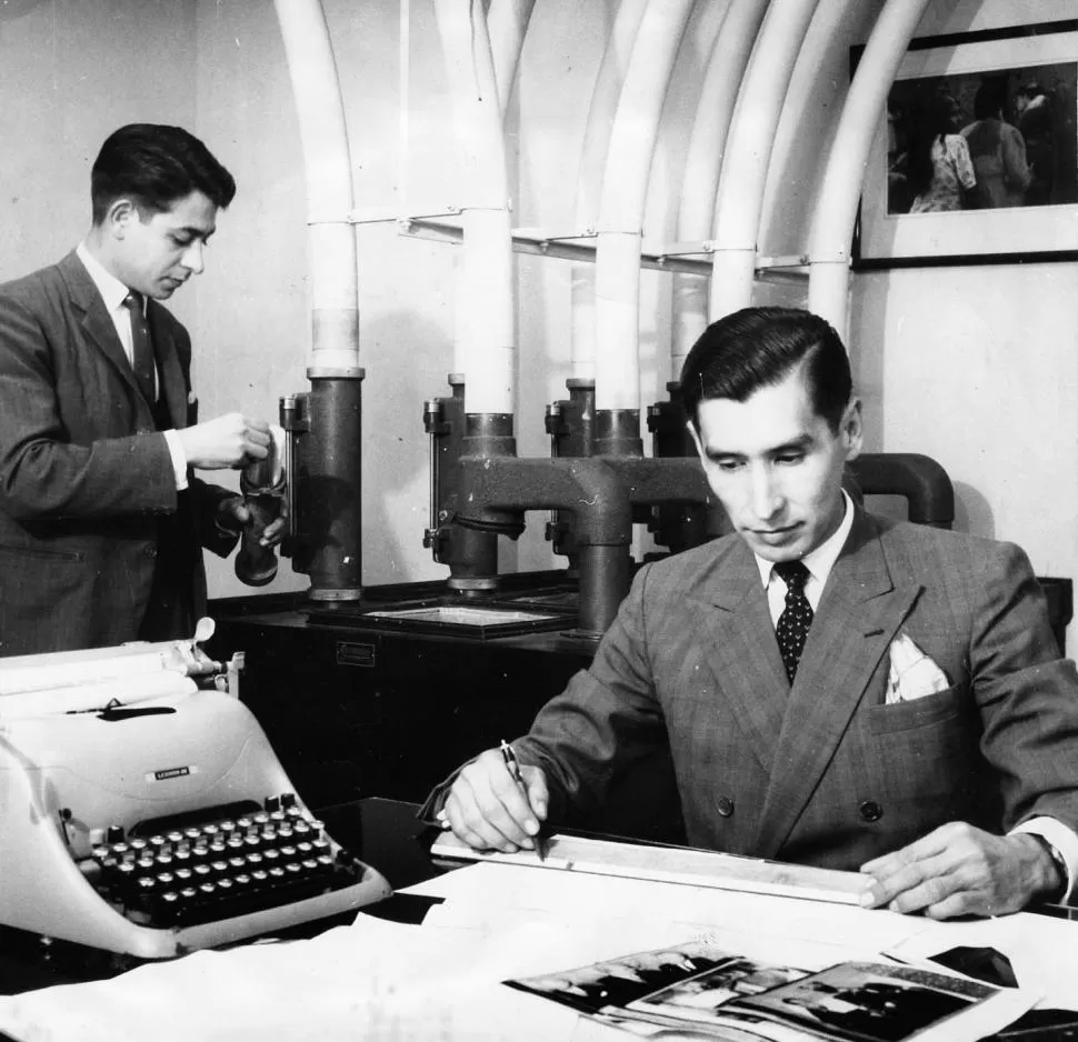 Fernando Villafañe, jefe de Cables, diagrama su página con lápiz y regla, en una foto de 1962. De pie, un periodista (Di Colantonio) colabora en la sección.