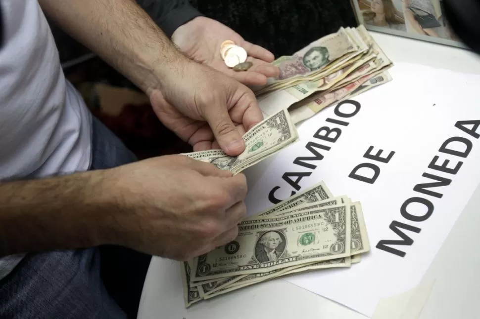 CURIOSA PROTESTA. En plena city porteña, miembros del Partido Liberal Libertario vendieron dólares a $5 en protesta a las restricciones oficiales. DYN