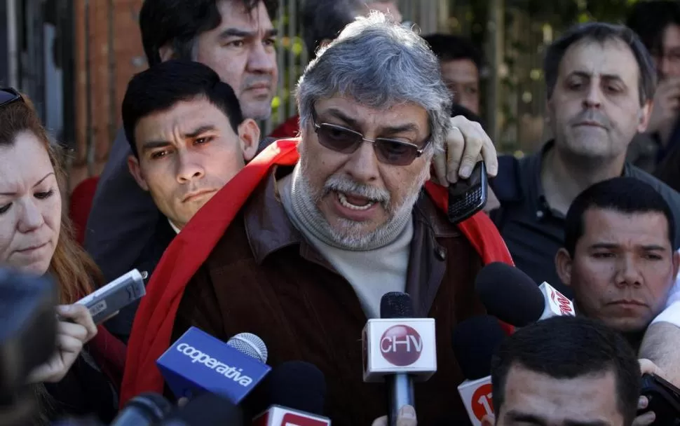 CONFERENCIA IMPROVISADA. Lugo, presidente destituido, responde a las preguntas de los periodistas a la salida de casa, en los suburbios de Lambaré. REUTERS