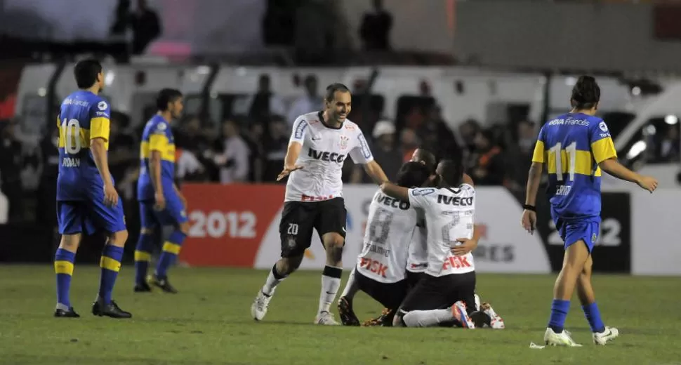 CONTRACARA. Los jugadores de Corinthians festejan el triounfo y la consagración ante los de Boca que sufrieron la derrota en el Pacaembú. DYN