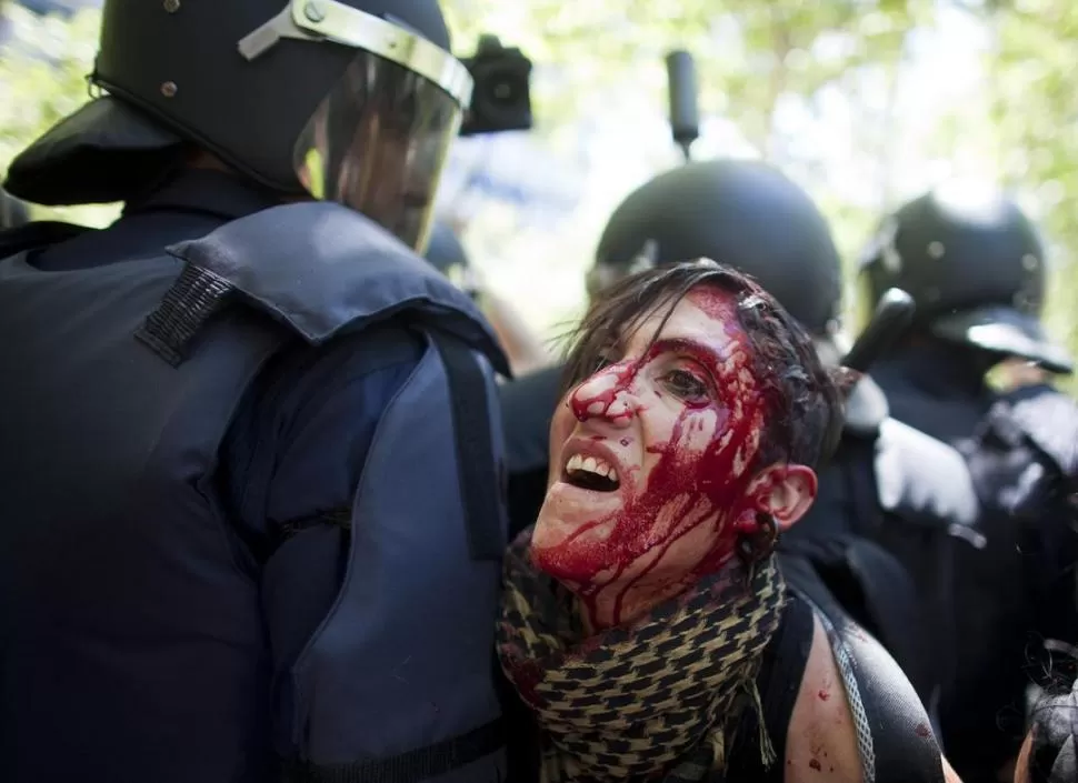 PROTESTA EN MADRID. El ajuste cuesta sangre, como la de esta manifestante, tras un choque con la Policía. REUTERS