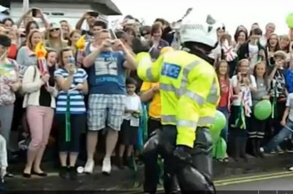 INSOLITO. La gente esperaba el paso de la antorcha olímpica y, en forma inesperada, un oficial de policía comenzó a bailar y a mostrar sus virtudes ante la sorpresa de la gente. FOTO CAPTURA DE VIDEO