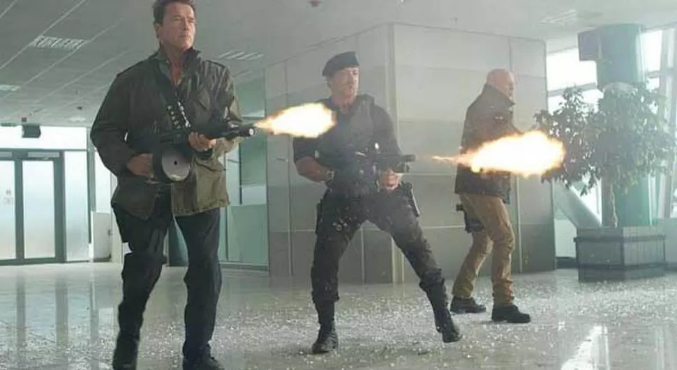 BALAS Y ADRENALINA. Schwarzenegger, Satallone y Willis en una de las escenas claves de la película.   