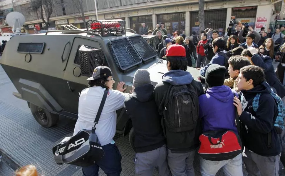 EN SANTIAGO. Un vehículo policial es detenido por los estudiantes. REUTERS