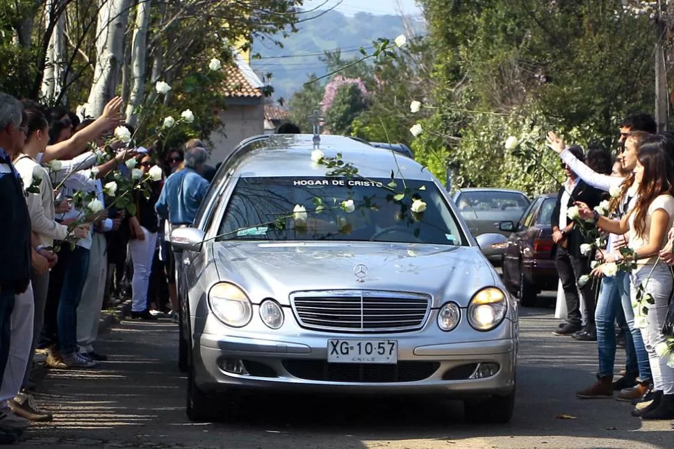 ULTIMO ADIOS. Un grupo de jóvenes arrojó rosas blancas al paso del vehículo fúnebre. DyN
