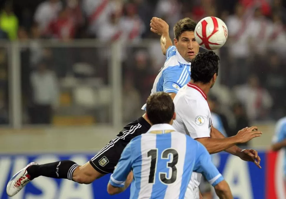 POR EL AIRE. Fernández lucha la tenencia del balón con un local, mientras Campagnaro acompaña la jugada. REUTERS