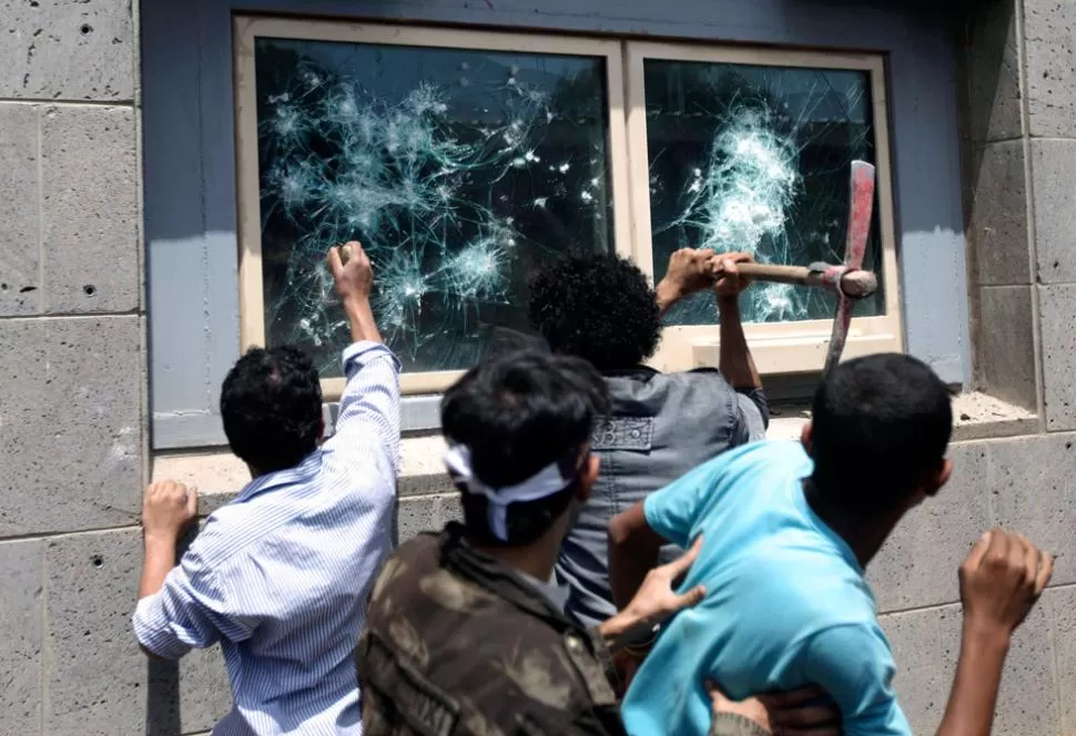 FURIA. Los rebeldes yemeníes intentaron romper los vidrios de una ventana para acceder a la embajada. REUTERS