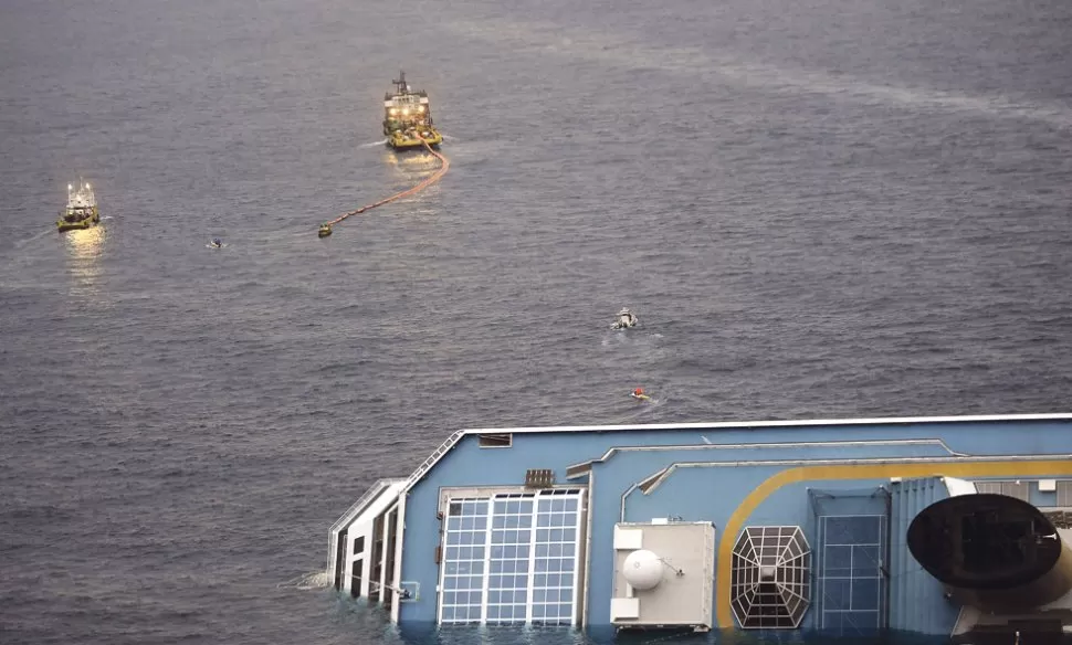 EXTRACCIÓN. Barcos absorben el vertido contaminante cerca del crucero. AFP