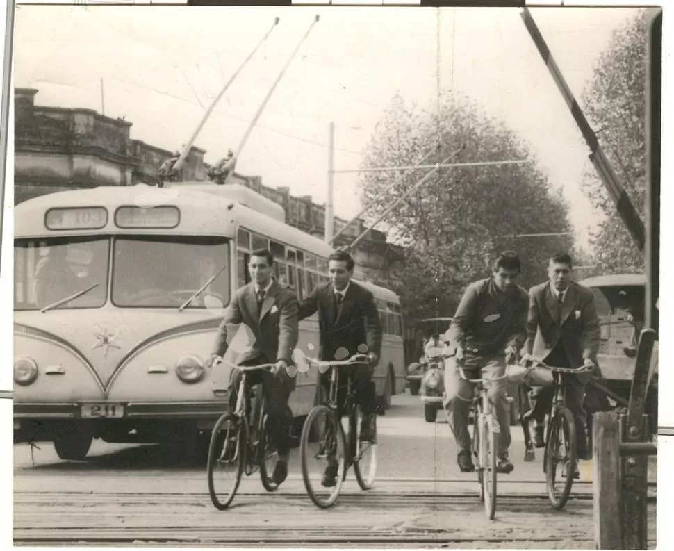 EN ACCIÓN. El 103 atraviesa las vías del Belgrano, en Juan B. Justo al 1.000, entre ciclistas de traje que retornaban a sus hogares. Era 1956.