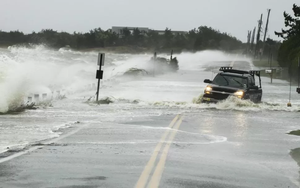 PELIGRO. Un vehículo se desplaza a duras penas por una ruta de Southampton, Nueva York, en medio del viento. REUTERS