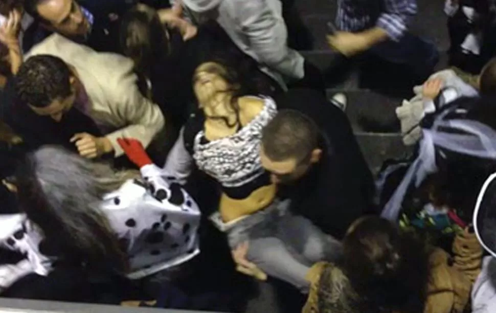DESESPERACION. Así sacaban a una de las víctimas de la estampida en el Madrid Arena. FOTO TOMADA DE EL PAIS / RAMIRO VILLANUEVA