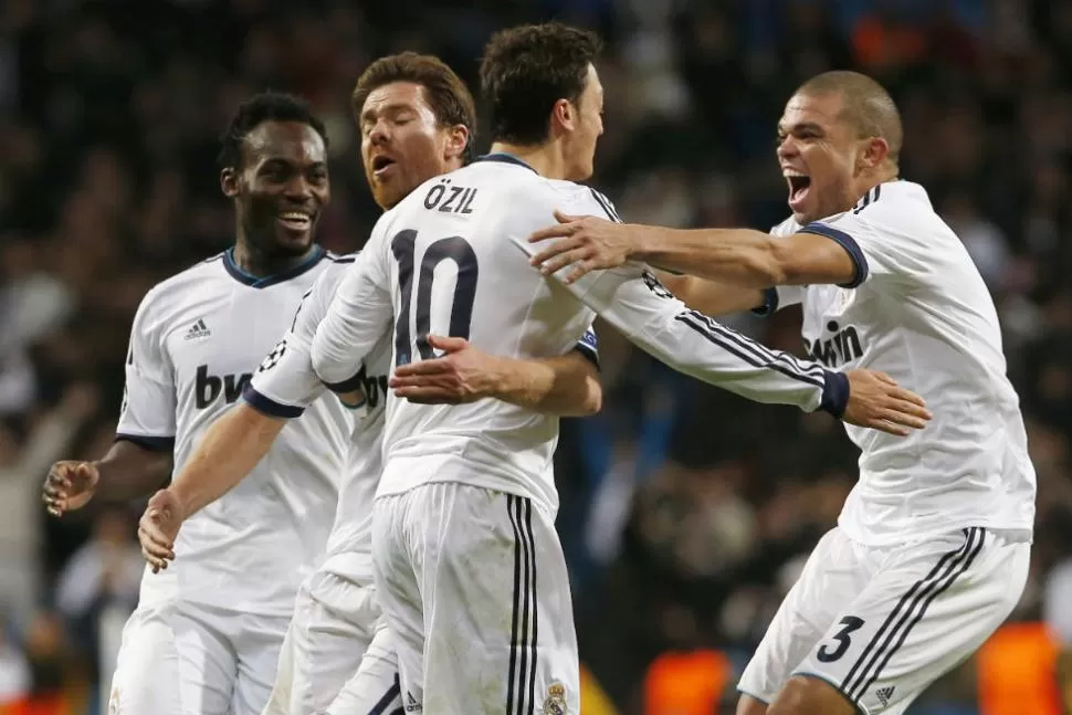 FESTEJO MERENGUE. Los jugadores de Real Madrid celebran el gol anotado por Özil a dos minutos del final del partido, lo que les permitió empatar con Borussia. REUTERS