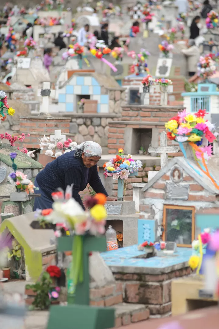 PLEGARIAS. En las tumbas, los vecinos rezan por sus seres queridos.   LA GACETA / FOTOS DE OSVALDO RIPOLL