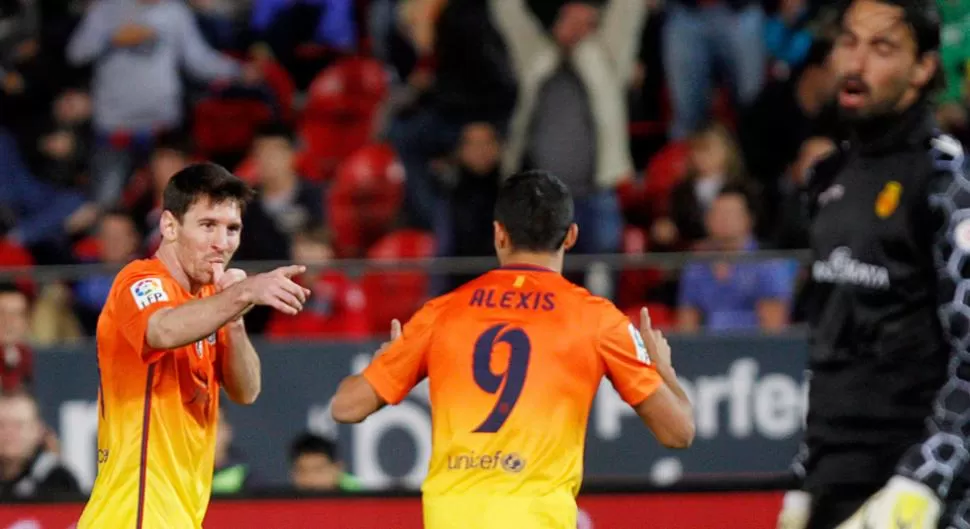 FESTEJO. Luego de anotar uno de los goles al Mallorca, Messi saluda al chileno Alexis Sánchez. REUTERS