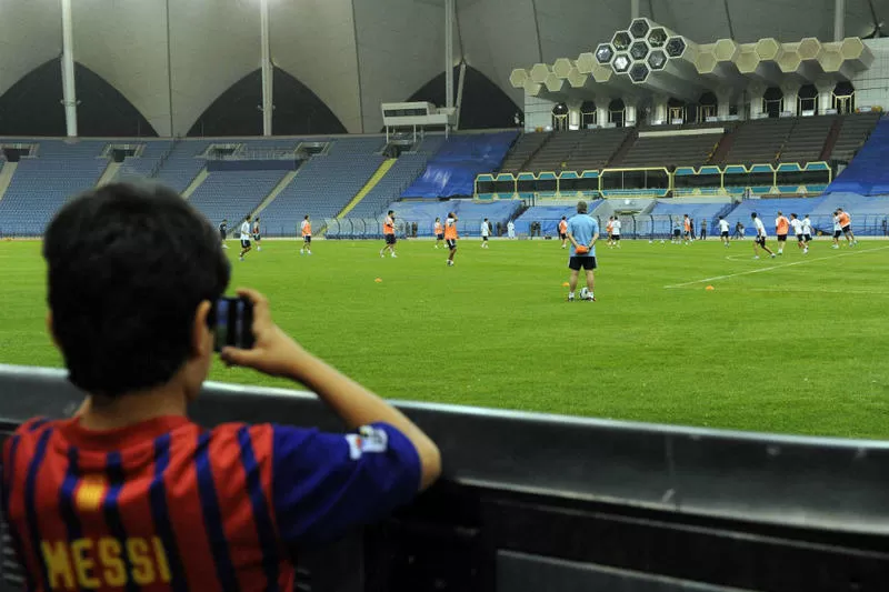 UNA MARAVILLA. Un niño, con la camiseta de Messi del Barcelona, observa el entrenamiento de la Selección. TELAM