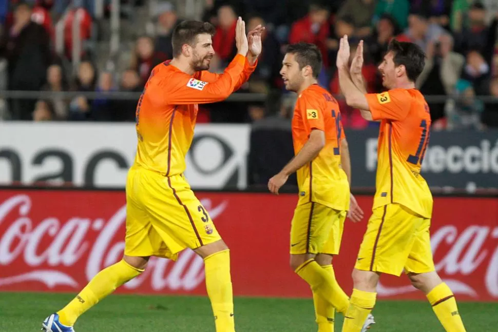 COMPAÑEROS. Piqué y Messi celebran un gol. REUTERS.