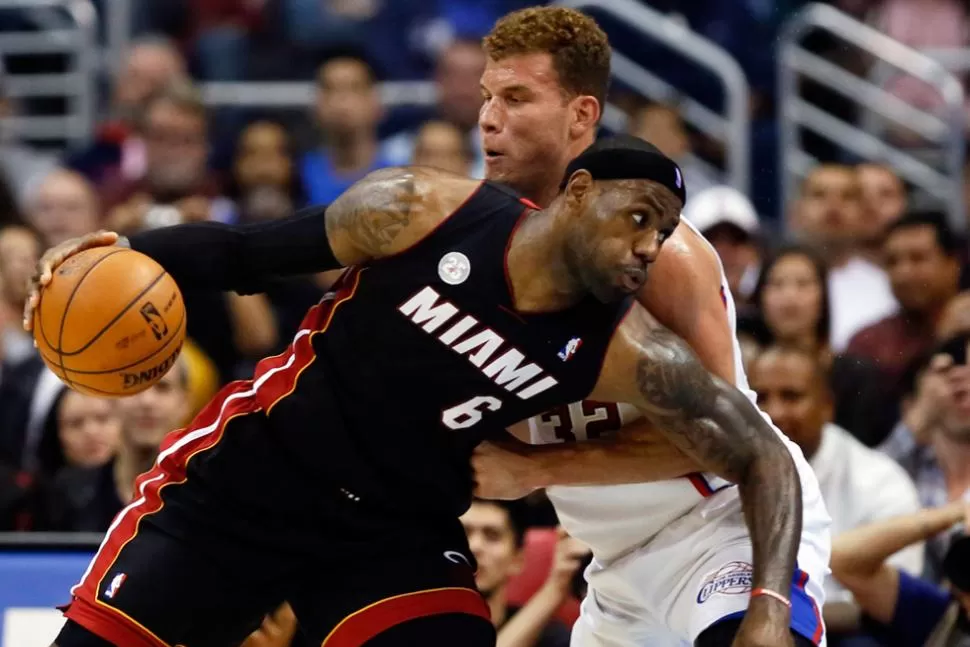 CUERPO A CUERPO. LeBron James, estrella de los Heat, trata de penetrar la defensa de Blake Griffin, de los Clippers. REUTERS