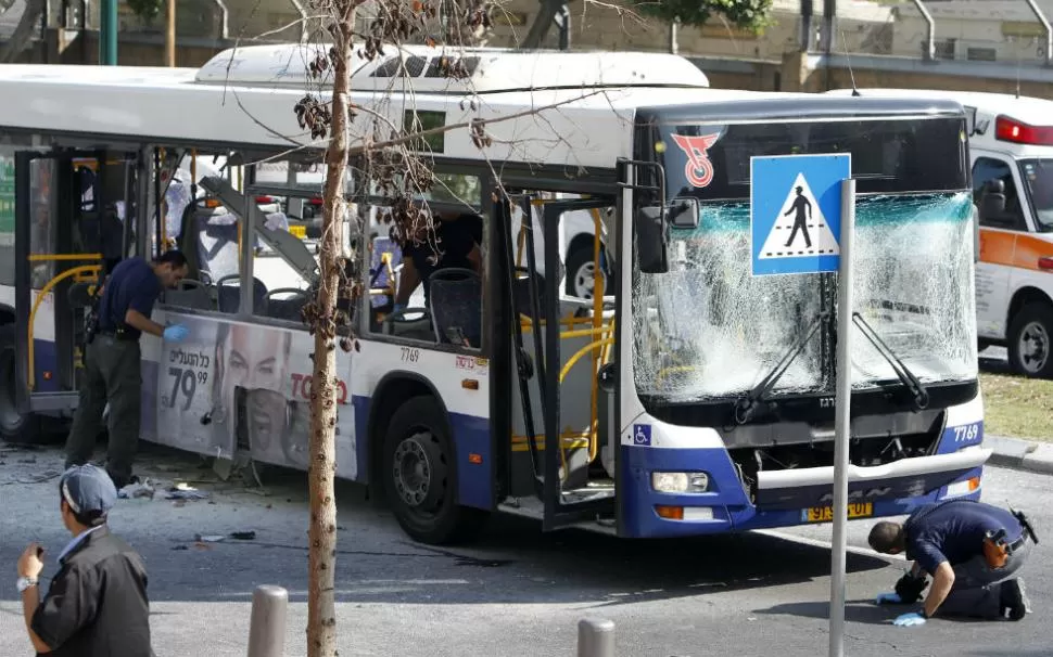 DESTROZOS. La Policía israelí revisa el ómnibus incendiado, en busca de indicios de que fue un atentado. REUTERS