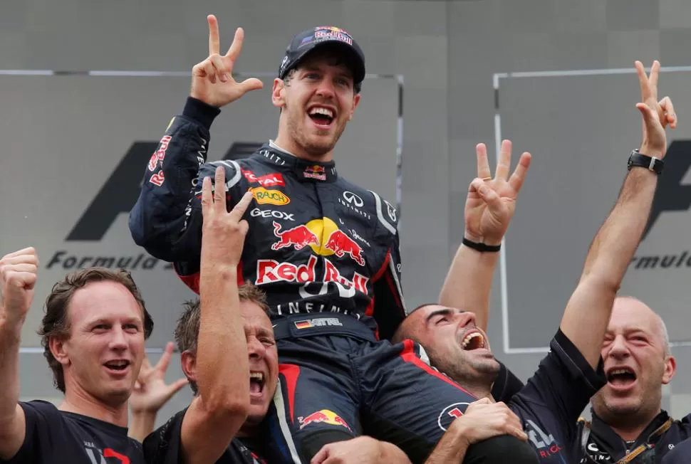 CELEBRACION. Junto a los integrantes de su equipo, Vettel festeja el tricampeonato en el circuito de Interlagos. REUTERS