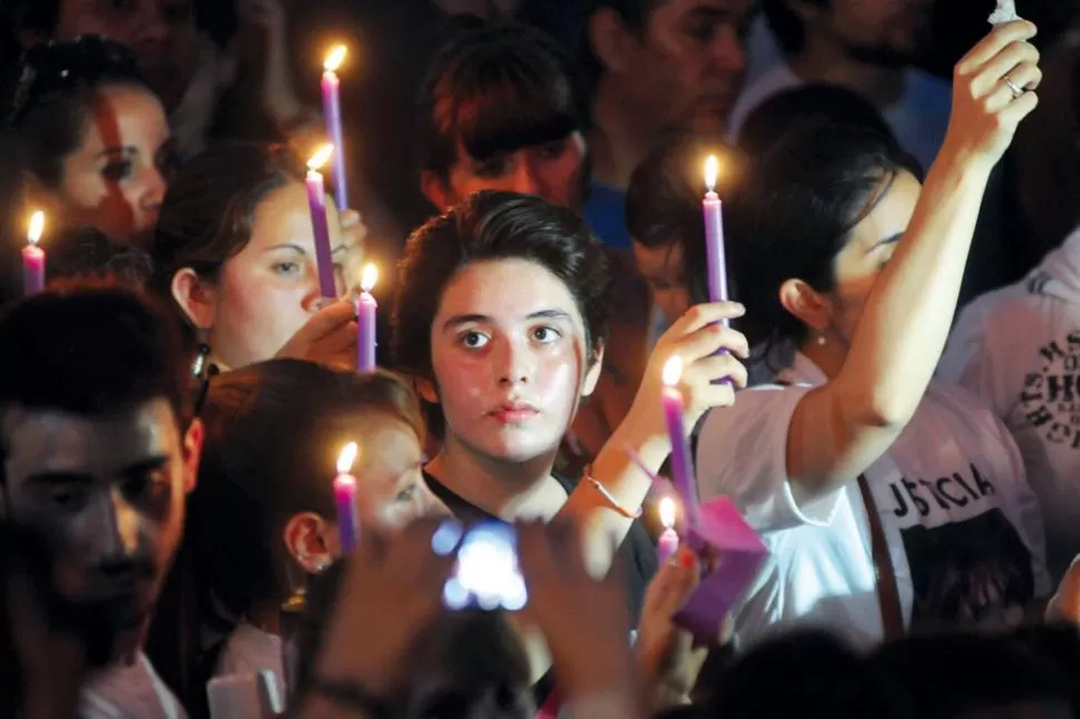LUCES DE LA ESPERANZA. Micaela Catalán (en el centro de la imagen) encendió velas violetas junto a otras jovencitas para recordar a su madre, que desapareció en 2002; con aerosoles, pintó consignas contra la trata de personas.