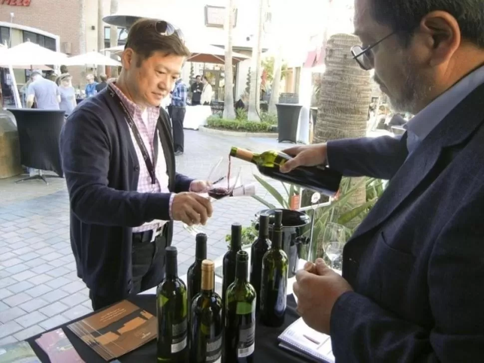 INTERÉS. Alberto Guardia hace degustar un vino tucumano a un visitante. GENTILEZA IDEP