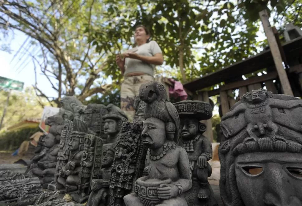 GRAN NEGOCIO. Una artesana mexicana ofrece figuras tradicionales mayas en un punto de venta en la ciudad de Copan. Puestos ofreciendo objetos similares se multiplican a lo largo de México, Guatemala y Honduras. REUTERS