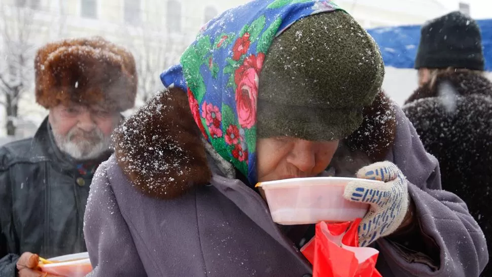 AYUDA. Voluntarios ofrecen comida caliente y te a los ciudadanos que no cuentan con un refugio para cubrirse de la ola de frío. REUTERS