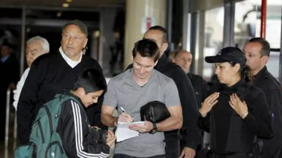 ENTRE FANATICOS. Messi no se cansa de firmar autógrafos. En Rosario llegó a la casa de una tía y lo esperaban muchos seguidores. 