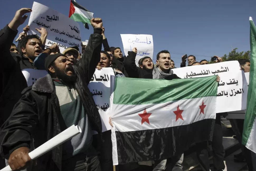 EN LA FRANJA DE GAZA. Un grupo de palestinos cantan consignas contrarias al régimen de Bashar al Assad. REUTERS