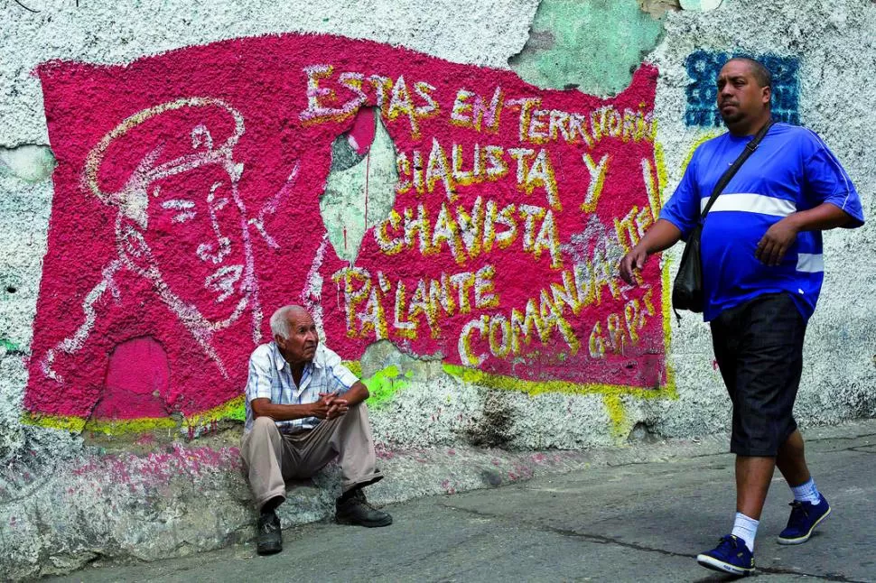 EN CARACAS. En un mural con la imagen del presidente se puede leer: Estas en territorio socialista y chavista, pa'alante comandante. REUTERS