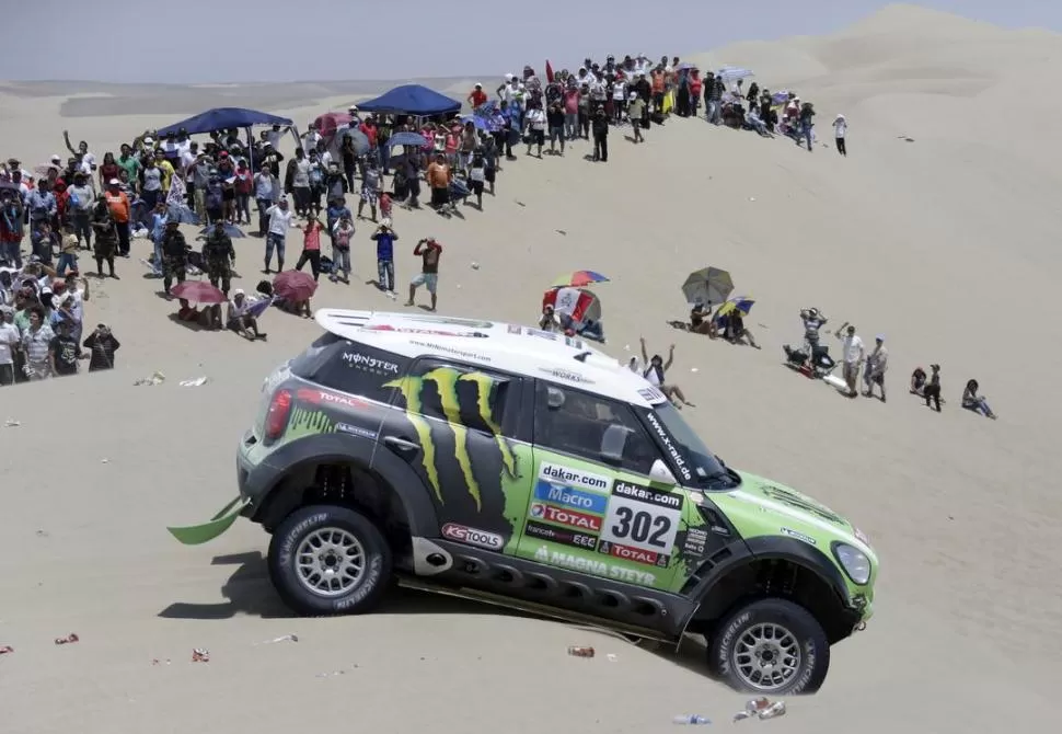 MANIOBRA JUSTA. Stephane Peterhansel maniobra su Mini, frente a una multitud, sobre la cresta de una duna. 