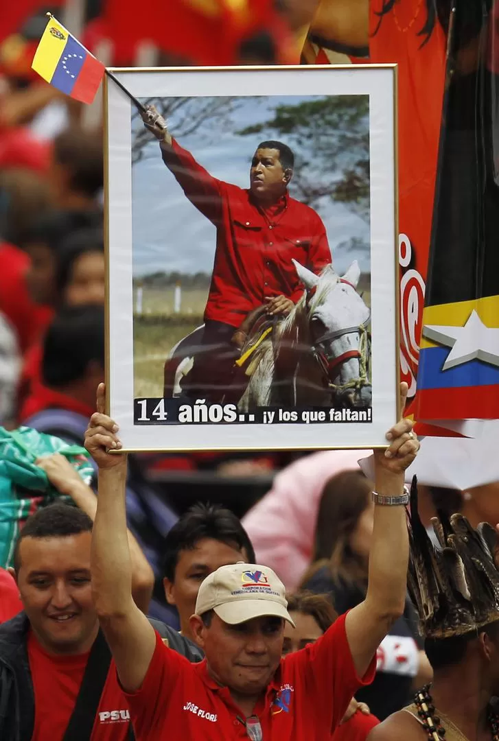 APOYO. Simpatizantes chavistas ondean la imagen del líder en Caracas. REUTERS