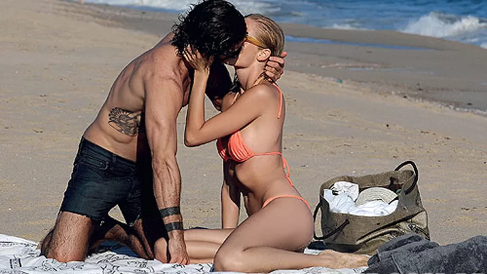 SOL, ARENA Y PASION. La modelo muestra todo su amor por su novio en las playas uruguayas. FOTO TOMADA DE GENTE.COM.AR
