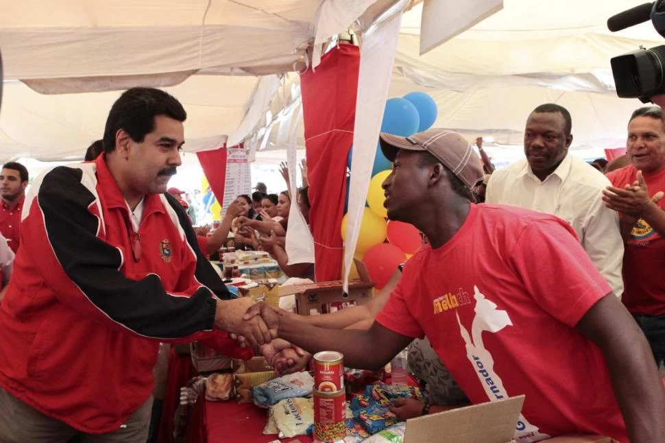 EN CARABOBO. Maduro saluda a uno de los simpatizantes del partido gobernante, en una feria venezolana. REUTERS