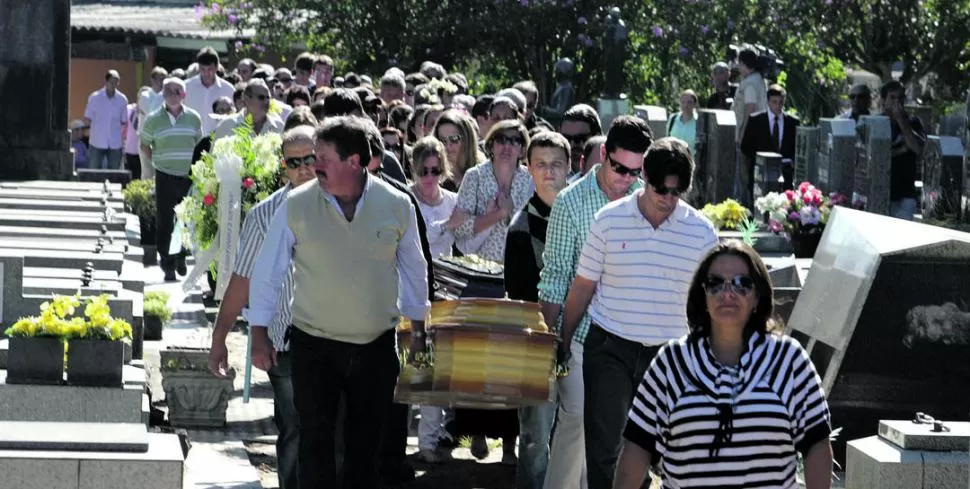 DOLOR SIN LÍMITES. Familiares de una de las 231 víctimas fatales llevan el féretro con sus restos al sepulcro, en el cementerio municipal de Santa María. TELAM