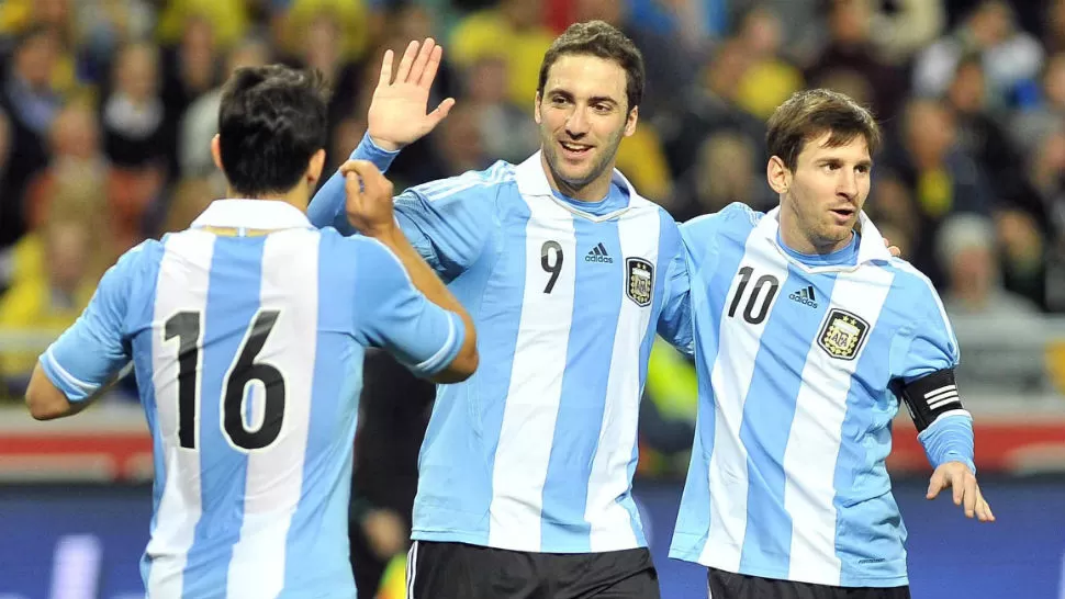 MAGIA. Gonzalo Higuaín festeja junto al Sergio Kun Aguero y Lionel Messi el primer gol. TELAM