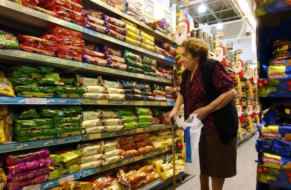 COMPARAR. Una mujer observa precios y productos frente a la góndola. 