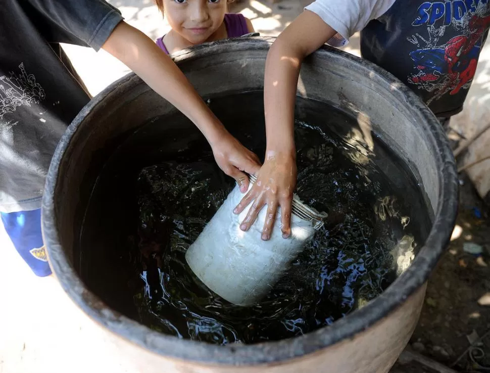 SIN OPCIONES. Los pobladores del barrio Las Palmeras deben juntar agua en tachos para poder cocinar y bañarse.  