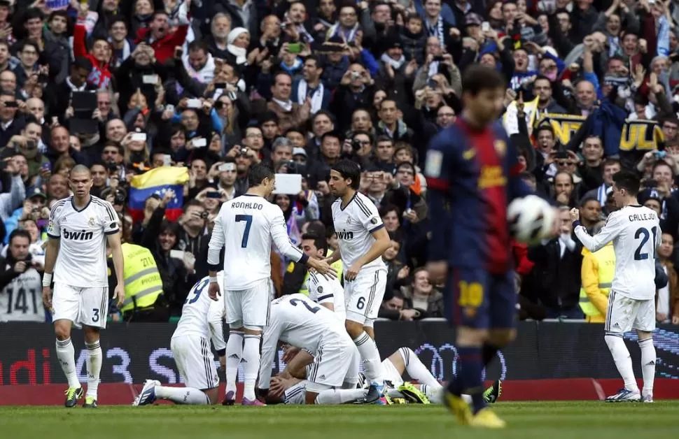 LAS DOS CARAS DE LA MONEDA. Ronaldo celebra con Khedira y sus compañeros el gol de Ramos. Messi, sufre. 