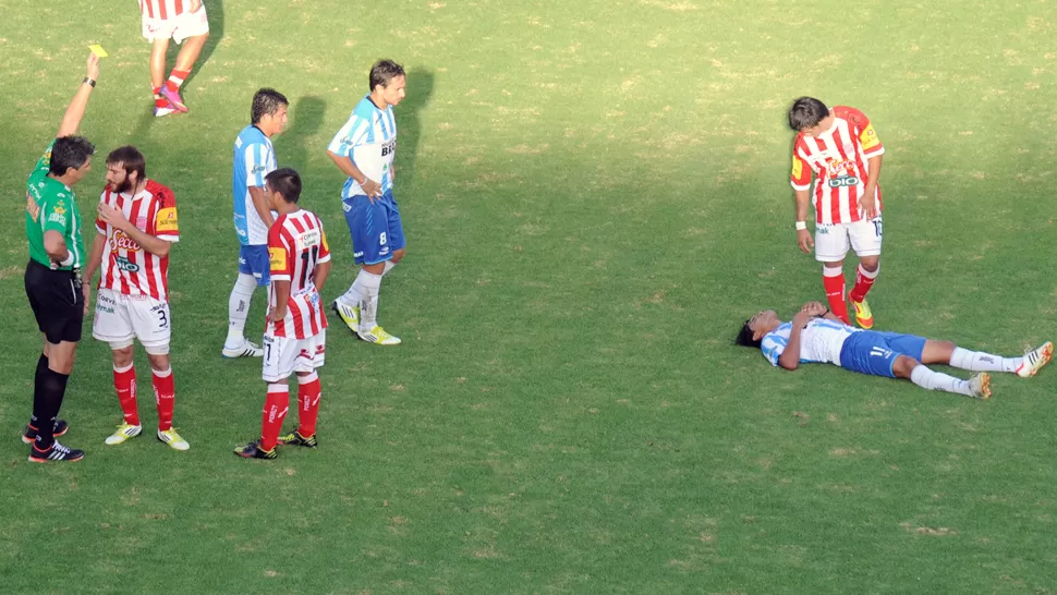 LA ESCENA. El árbitro amonesta a un jugador de San Martín, mientras otro de Atlético se recupera de una falta. LA GACETA / FOTO DE JUAN PABLO SANCHEZ NOL I