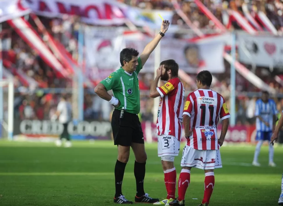 LO SUFRE GOICOECHEA. Maglio le muestra la tarjeta amarilla al defensor de San Martín. El árbitro amonestó a cuatro jugadores y expulsó a Mario Vera. 