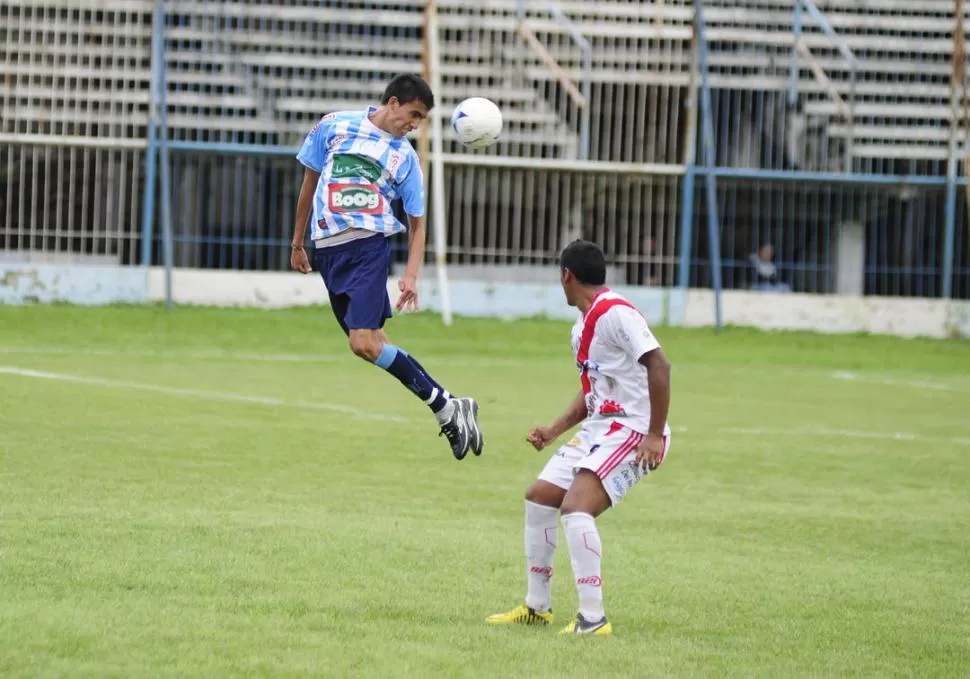 EN LAS ALTURAS. Ariel Décima, de los leones, despeja la pelota ante la marca de Horacio Fernández, de los salteños. 